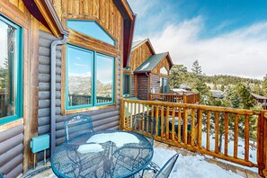 A wooden cabin with a balcony, a table, and chairs. - Two BR Condo w/ Brand NEW HOT TUB and Great Views! (Estes Park)