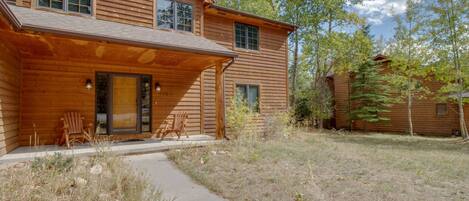 A wooden cabin with a covered porch, a front door, and a visible number '170'.