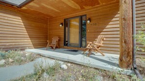 Puuinen mökki, jossa on kuisti, kaksi Adirondack-tyylistä puutarhatuolia ja ovi, jossa on numero ’470’.