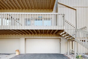 A two-story building with a balcony, a garage, and a staircase. - Comfortable Home With Breathtaking Mountain Views and High-speed Wifi (Estes Park)