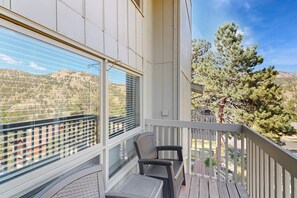 A balcony with a view of a mountainous landscape, a chair, and a table. - Comfortable Home With Breathtaking Mountain Views and High-speed Wifi (Estes Park)
