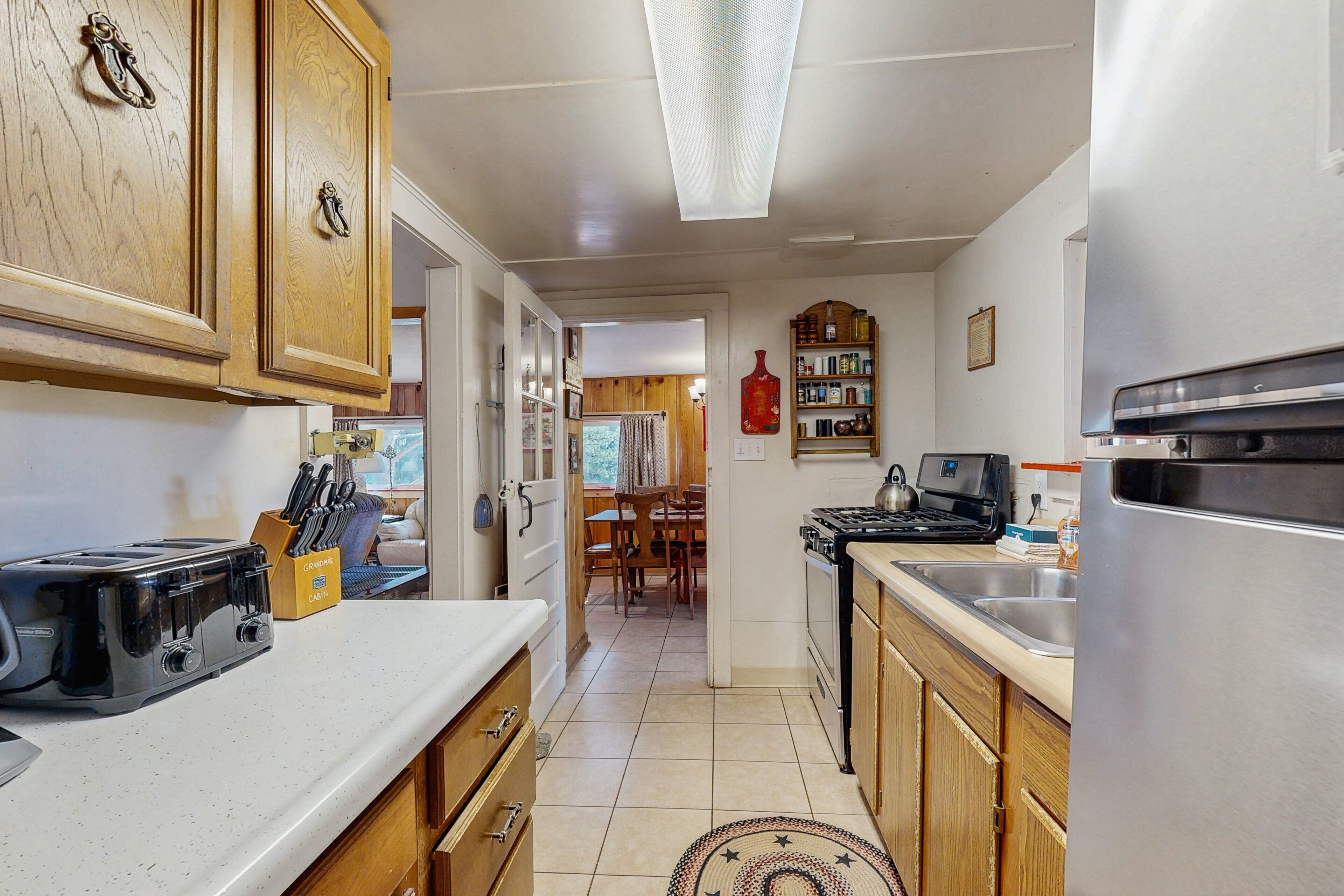 A kitchen with wooden cabinets, a toaster, a stove, and a refrigerator.