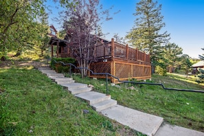 Eine Holzterrasse mit einer Treppe, die zu einem Haus führt.
