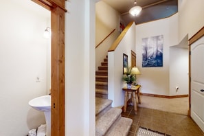 Eine Treppe mit Holzbalkonen, eine weiße Tür und ein gerahmtes Bild an der Wand.