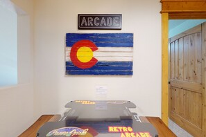 Une salle d’arcade à l’ancienne, avec une enseigne indiquant « ARCADE » et un drapeau de l’État du Colorado.