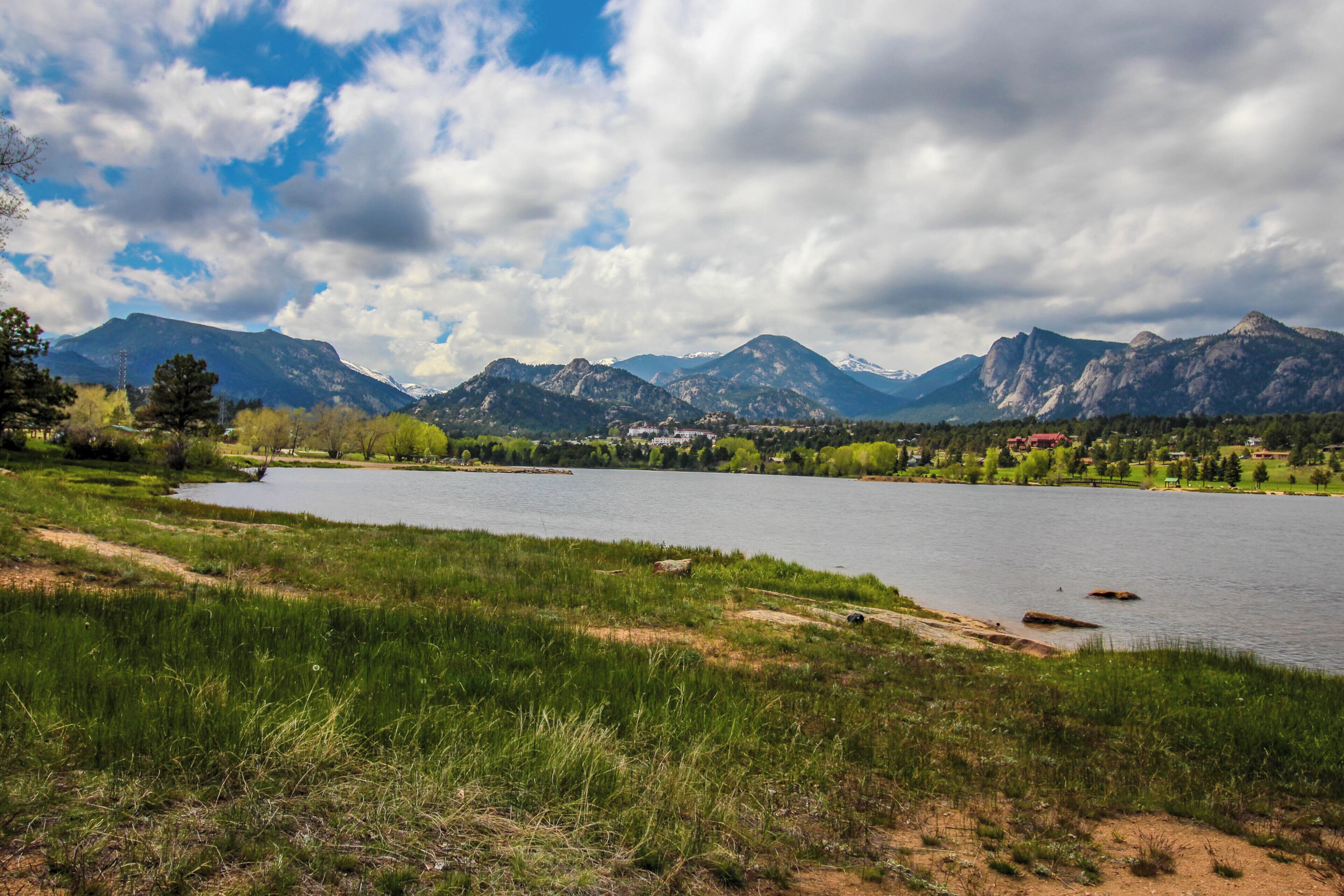 Ein See, umgeben von Bergen und Grün.