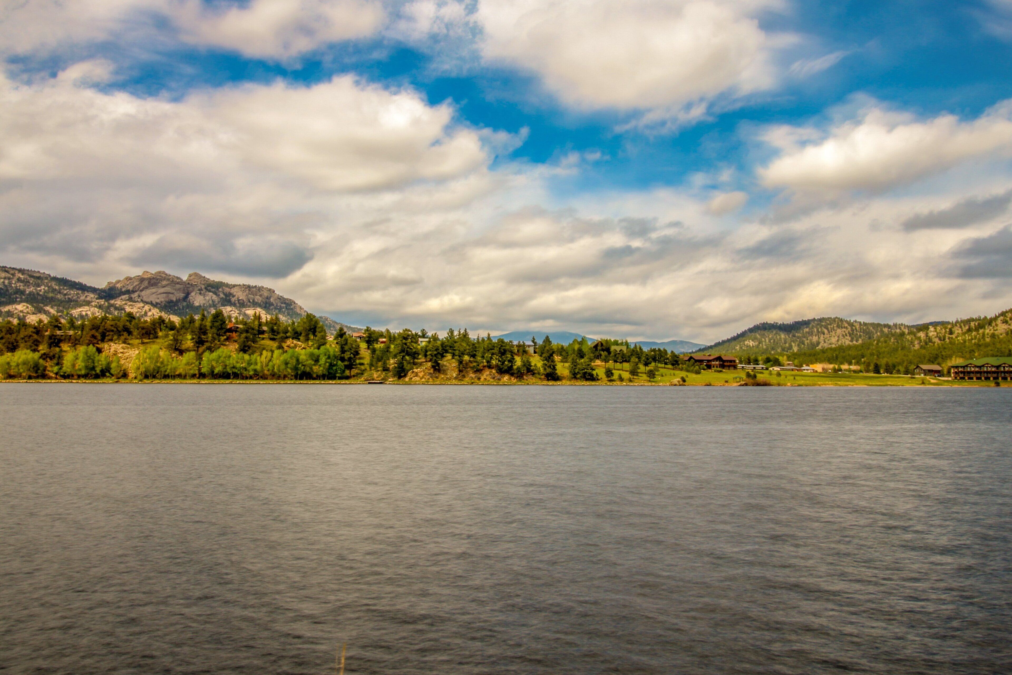 Un lac avec des montagnes en arrière-plan et un ciel dégagé.