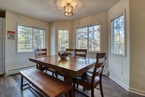 A dining room with a wooden table, chairs, and a chandelier. - Relaxing Condo in Estes Park w/ a Full Kitchen, gas Fireplace, & Furnished Deck (Estes Park)