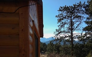 A wooden cabin with a view of a pine tree and mountains in the background. - Cabin on 7 Acres With Glorious Mountain Views & Wood Fireplace (Estes Park)