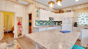 Eine Küche mit Holzwänden, einer Granit Arbeitsplatte und einem Kühlschrank.