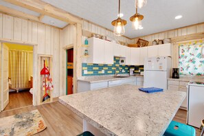 Eine Küche mit Holzwänden, einer Granit Arbeitsplatte und einem Kühlschrank.