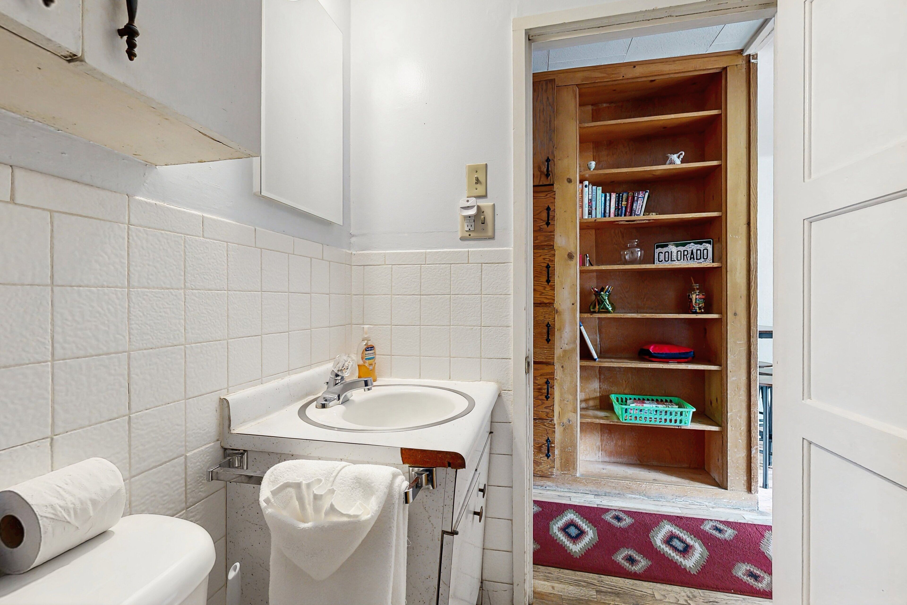 A bathroom with a toilet, sink, and towel rack.