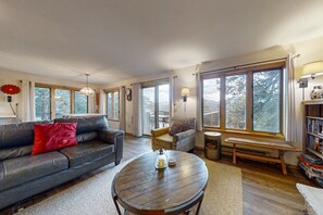 A living room with a sofa, a round coffee table, a bench, and a bookshelf. - Inviting Cabin With Stellar Panoramic Rocky Mountain Views (Estes Park)