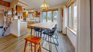 A spacious kitchen with a large island, wooden flooring, and a hanging light fixture. - Inviting Cabin With Stellar Panoramic Rocky Mountain Views (Estes Park)