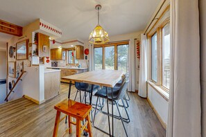 A spacious kitchen with a large island, wooden flooring, and a hanging light fixture. - Inviting Cabin With Stellar Panoramic Rocky Mountain Views (Estes Park)