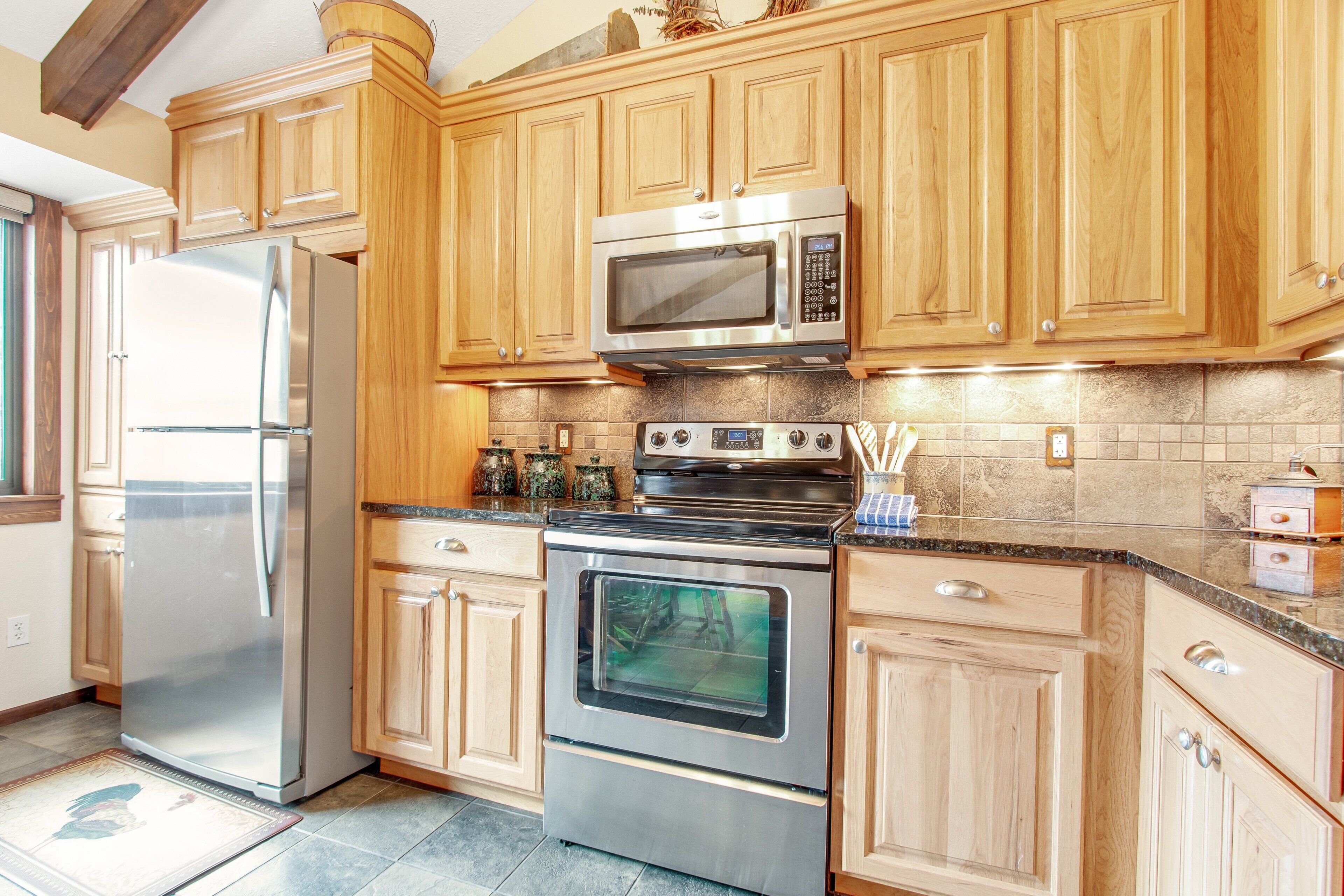 A kitchen with wooden cabinets, stainless steel appliances, and a tiled backsplash.