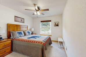 A bedroom with a bed, a ceiling fan, a window, and a nightstand. - Conveniently Located Home w/ Full Kitchen, Deck & Mountain Views (Estes Park)