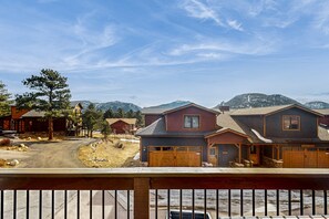 A residential area with houses, a driveway, and mountains in the background.