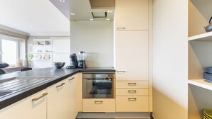 A compact kitchen with a built-in oven, a coffee maker, and a sink. - 1 bedroom accommodation in Oostduinkerke (Oostduinkerke)