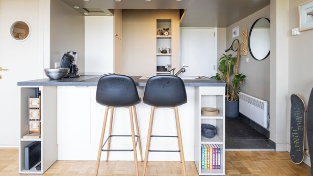 A modern kitchen with two bar stools, a coffee machine, and a potted plant. - 1 bedroom accommodation in Oostduinkerke (Oostduinkerke)
