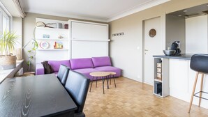 A modern living space with a sofa, dining table, and kitchen area. - 1 bedroom accommodation in Oostduinkerke (Oostduinkerke)