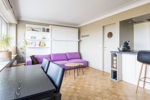 Ein stilvoller Wohnbereich mit Sofa, Esstisch und Küchenzeile.