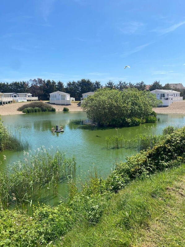 Vista del lago con casas móviles y un pequeño bote.