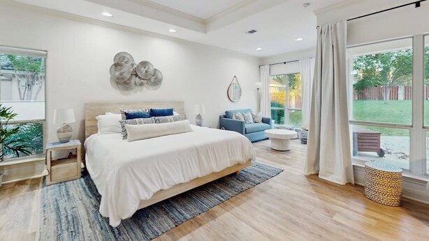 A bedroom with a large bed, a ceiling fan, a window with curtains, and a view of the outdoors. - Modern Home Near Lake LBJ With Enclosed Yard, Patio, Grill & Central AC (Horseshoe Bay)