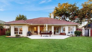 A two-story house with a covered patio, a lawn, and a tree. - Modern Home Near Lake LBJ With Enclosed Yard, Patio, Grill & Central AC (Horseshoe Bay)