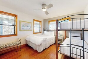 A bedroom with a bunk bed, a single bed, a bedside table, a chair, and a ceiling fan. - Peaceful Home With Fire Pit, Gazebo, Patio, & Amazing Deck Views - Dog-friendly (Fredericksburg)