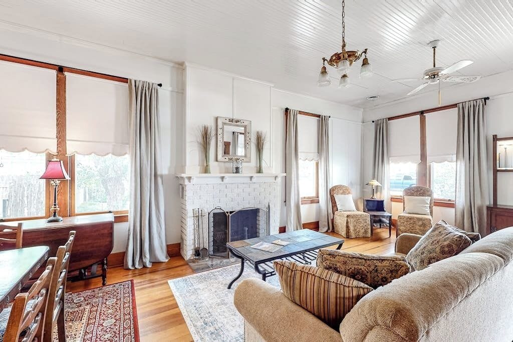 A living room with a fireplace, a dining area, and a sofa.