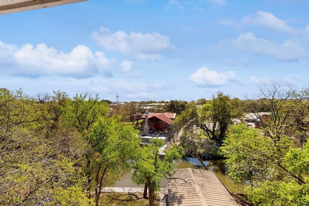A river with trees and a building with a red roof.