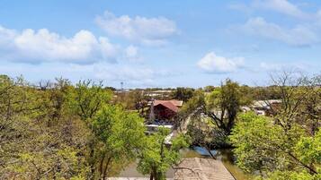 A river with trees and a building with a red roof.