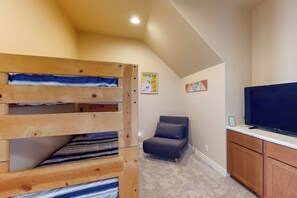 A room with a bunk bed, a television, a cabinet, and a poster on the wall. - Waterfront Home With Game Room, Decks, Pool, Smart Tvs, Kayaks, & Gas Grill (Kingsland)