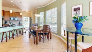 A kitchen with a dining area, wooden cabinets, a microwave, and a large window. - Waterfront Home With Game Room, Decks, Pool, Smart Tvs, Kayaks, & Gas Grill (Kingsland)