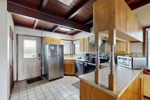 A kitchen with wooden cabinets, a stainless steel refrigerator, a microwave, and a stove. - Classic Lakefront Cottage With Private Dock, Lovely Lake View, Backyard & Wifi (Kingsland)