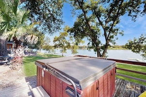 Un jacuzzi en una terraza de madera con vista al lago.
