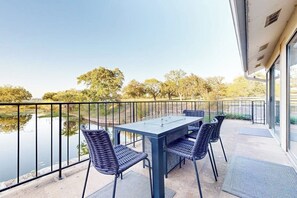 A balcony with a table and chairs overlooking a body of water and trees. - Dog-friendly Waterfront Retreat With a Washer/dryer, Furnished Patio, & AC (Horseshoe Bay)