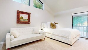A bedroom with a white bed, a white sofa, a framed picture on the wall, and a large window. - Dog-friendly Waterfront Retreat With a Washer/dryer, Furnished Patio, & AC (Horseshoe Bay)