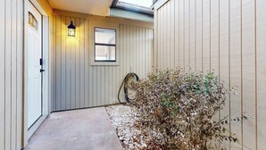 A narrow hallway with a door, a window, and a small plant. - Dog-friendly Waterfront Retreat With a Washer/dryer, Furnished Patio, & AC (Horseshoe Bay)