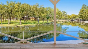 A covered outdoor area with a view of a lake and trees. - Lakefront Dog-friendly Home With Kayaks, Sup's, Huge Screened Porch (Burnet)