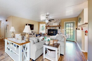 A living room with a fireplace, a sofa, a coffee table, and a television. - Dog-friendly, Secluded Home 2 Miles to Main St. With Firepit, Gazebo & BBQ Pit (Fredericksburg)