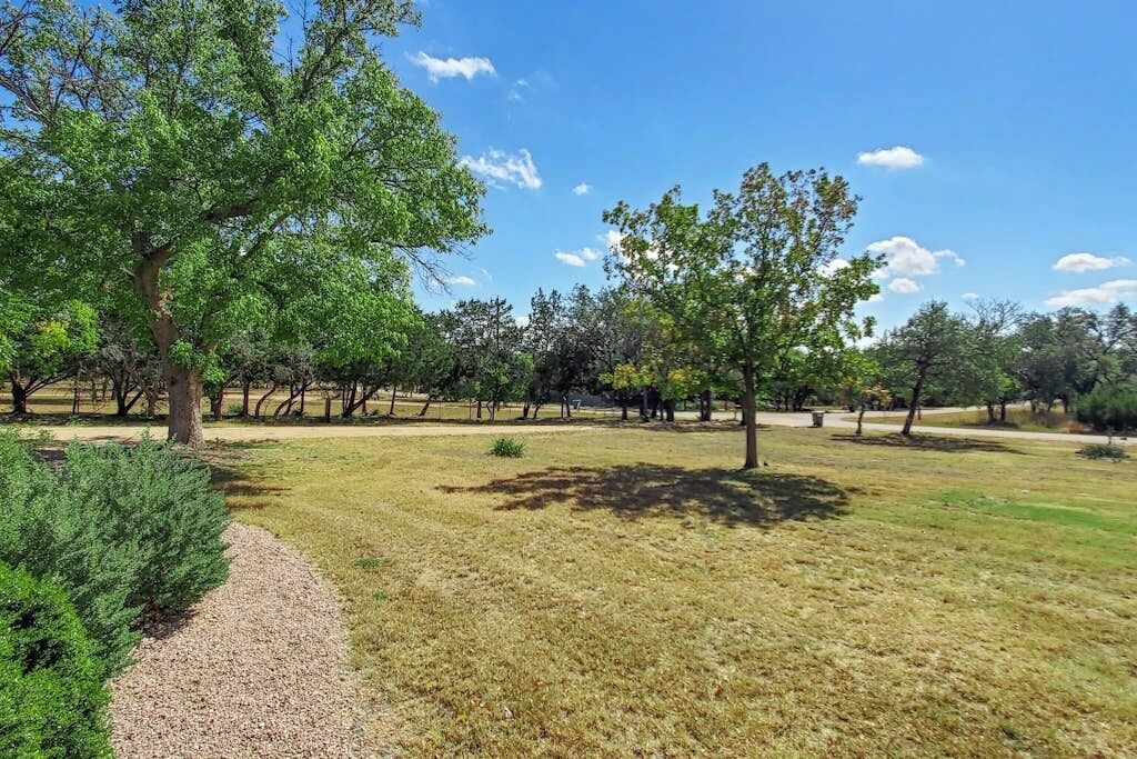 A park with trees and a gravel path.