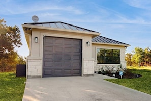 A single-story house with a garage, a satellite dish, and a small window. - Stunning Lake House With Spacious Bedrooms - Minutes to Local Attractions (Horseshoe Bay)