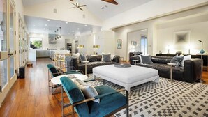 A spacious living area with a large sofa set, a coffee table, and a patterned rug. - Inviting Waterfront Home With Pool, Patio, Fireplace, W/d, & Dog-friendly (Hunt)