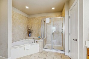 A bathroom with a bathtub, a shower enclosure, and a sink. - Dog-friendly & Spacious Condo With Lake Views, Large Balcony, & Pool (Horseshoe Bay)