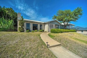 A modern two-story house with a stone facade, a covered porch, and a well-maintained lawn.