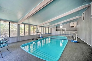 An indoor swimming pool with a net, a chair, and a table. - Snowbird-friendly House With Game Room, Full Kitchen, Balcony & W/D (Kerrville)