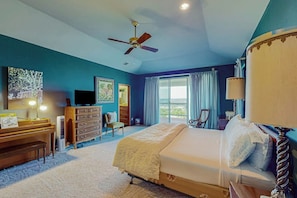 A bedroom with a bed, a desk, a chair, a television, and a ceiling fan. - 2-story Home With Covered Patio, Balcony, Fireplace, Streaming, Great Views, W/D (Kerrville)