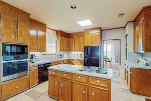A kitchen with wooden cabinets, stainless steel appliances, and a large island. - 2-story Home With Covered Patio, Balcony, Fireplace, Streaming, Great Views, W/D (Kerrville)